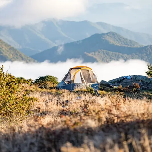 Tente de camping en alpage au-dessus des nuages