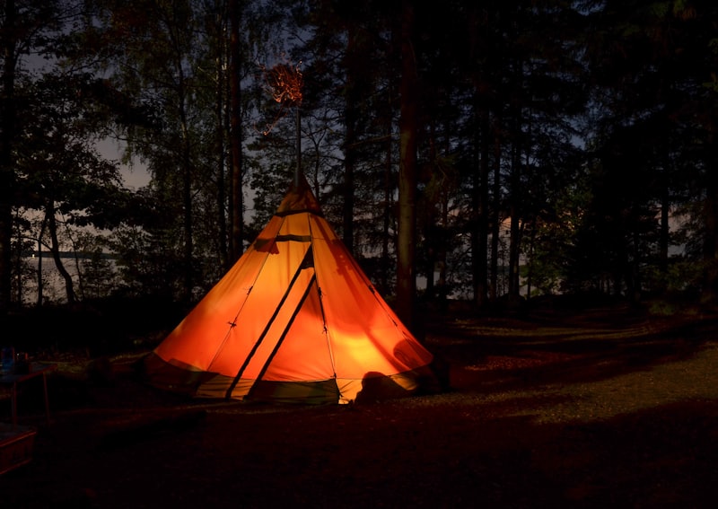 Tente tipi illuminée la nuit en forêt
